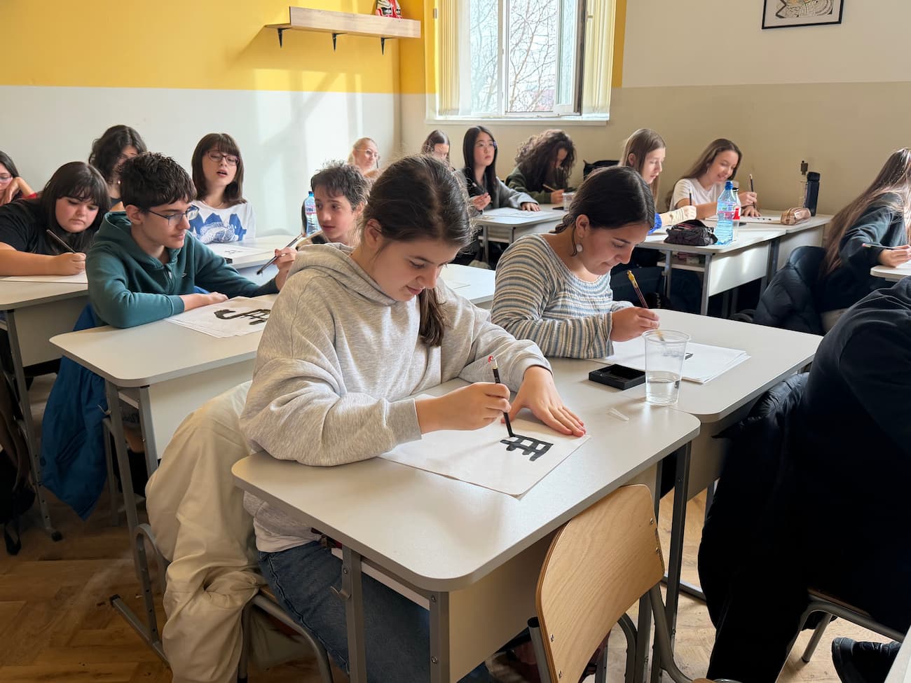 Photo 5 – Students writing the Chinese character “马” (horse)