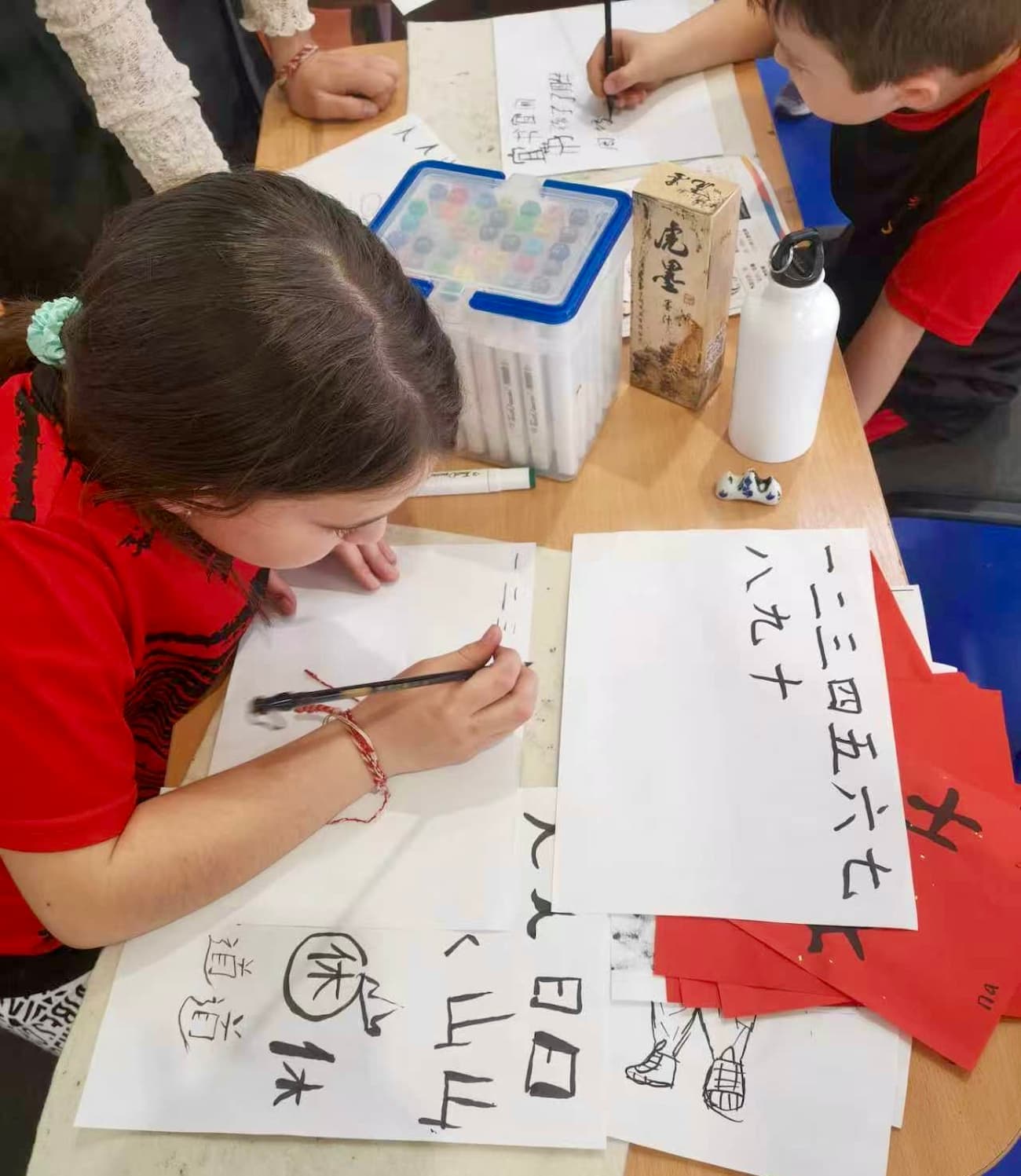  Photo 5: Learning to write Chinese characters